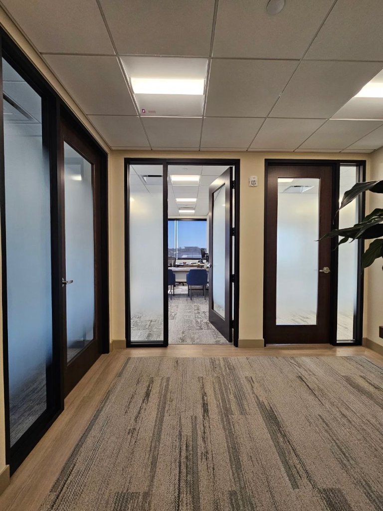 Decorative privacy film on glass doors along an interior corridor
