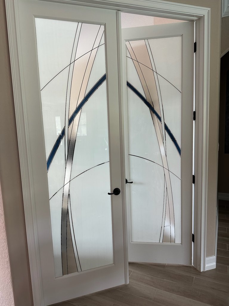 Bold curved accents on white-framed double entry doors