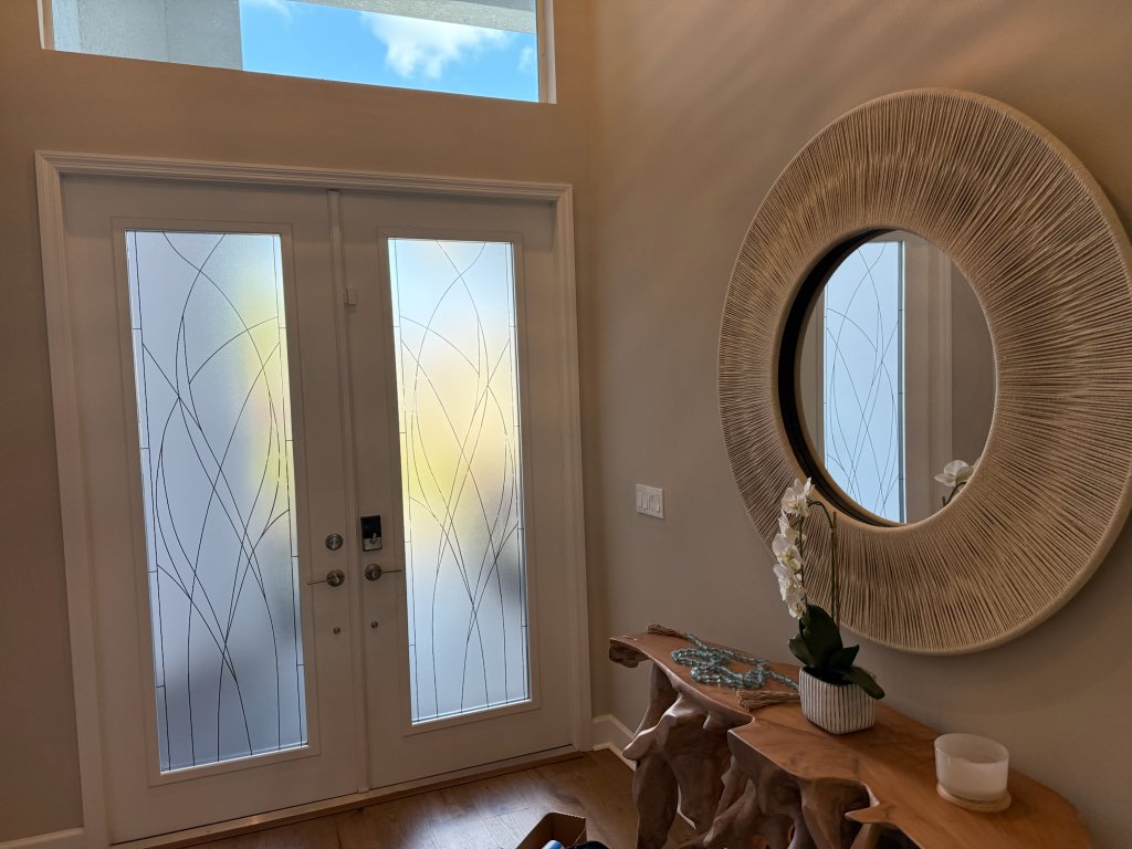 Fine curved linework on entry doors and a sidelight