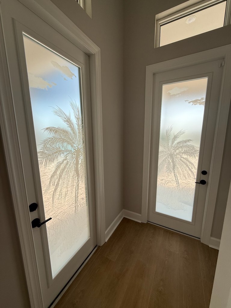 Palm artwork on entry doors and adjoining windows