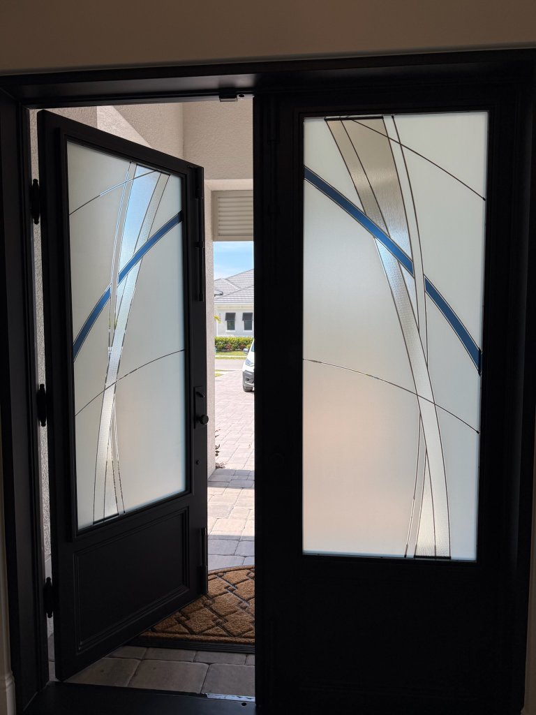 Sweeping dark accents on open black-framed double entry doors