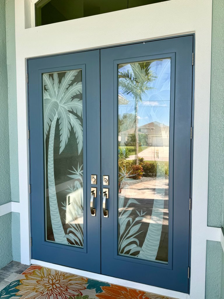 Palm artwork on blue-framed double entry doors