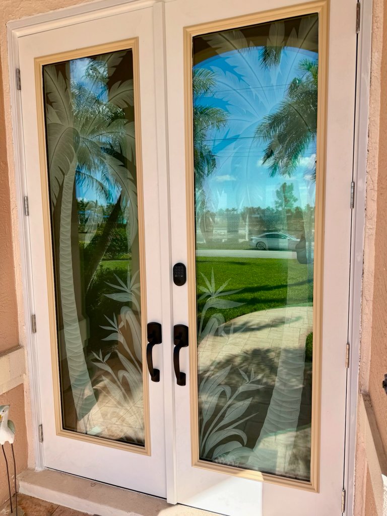 Palm artwork on open double entry doors