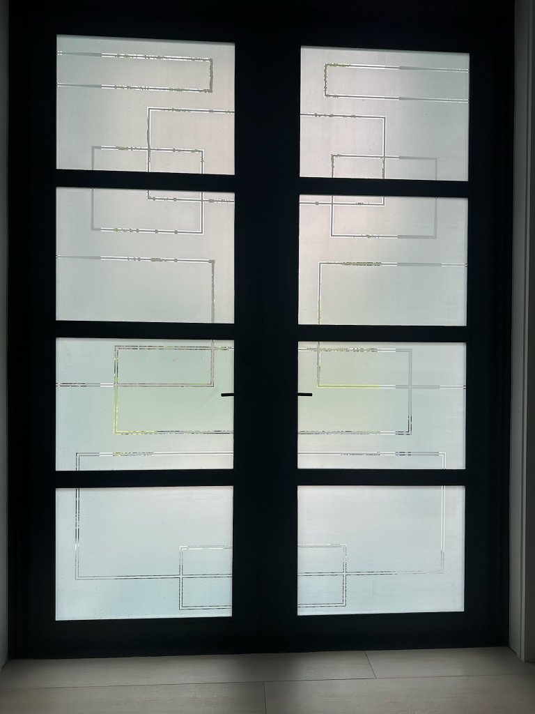 Frosted geometric linework across divided double-door panes