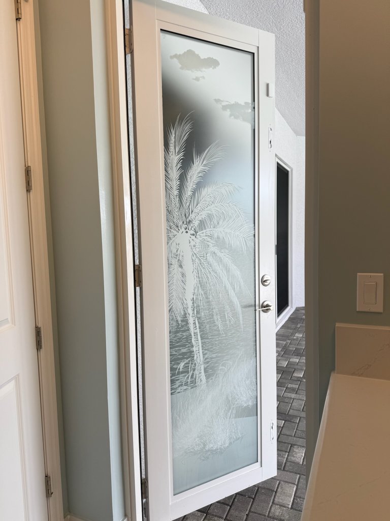 Palm artwork on an open white-framed entry door