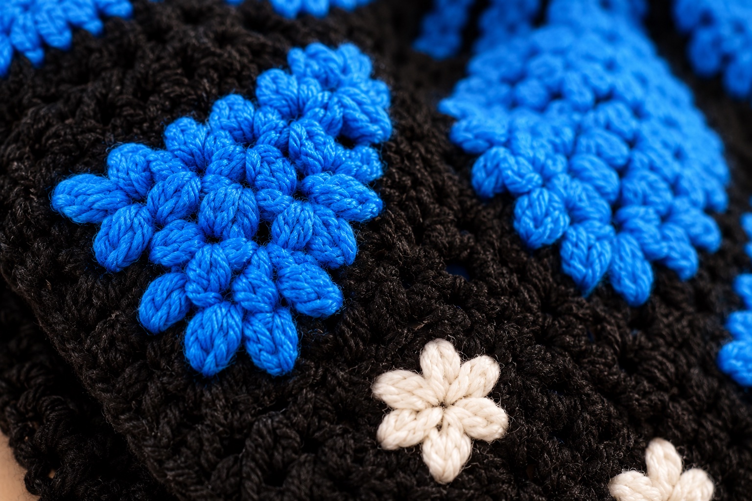Detalhe dos pontos do Cardigan Borboleta em azul e preto com flores