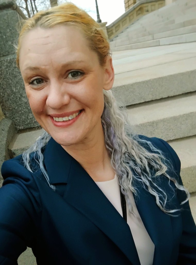 Ashley Marie Meredith sitting on the steps of the Iowa State Capitol in March 2026