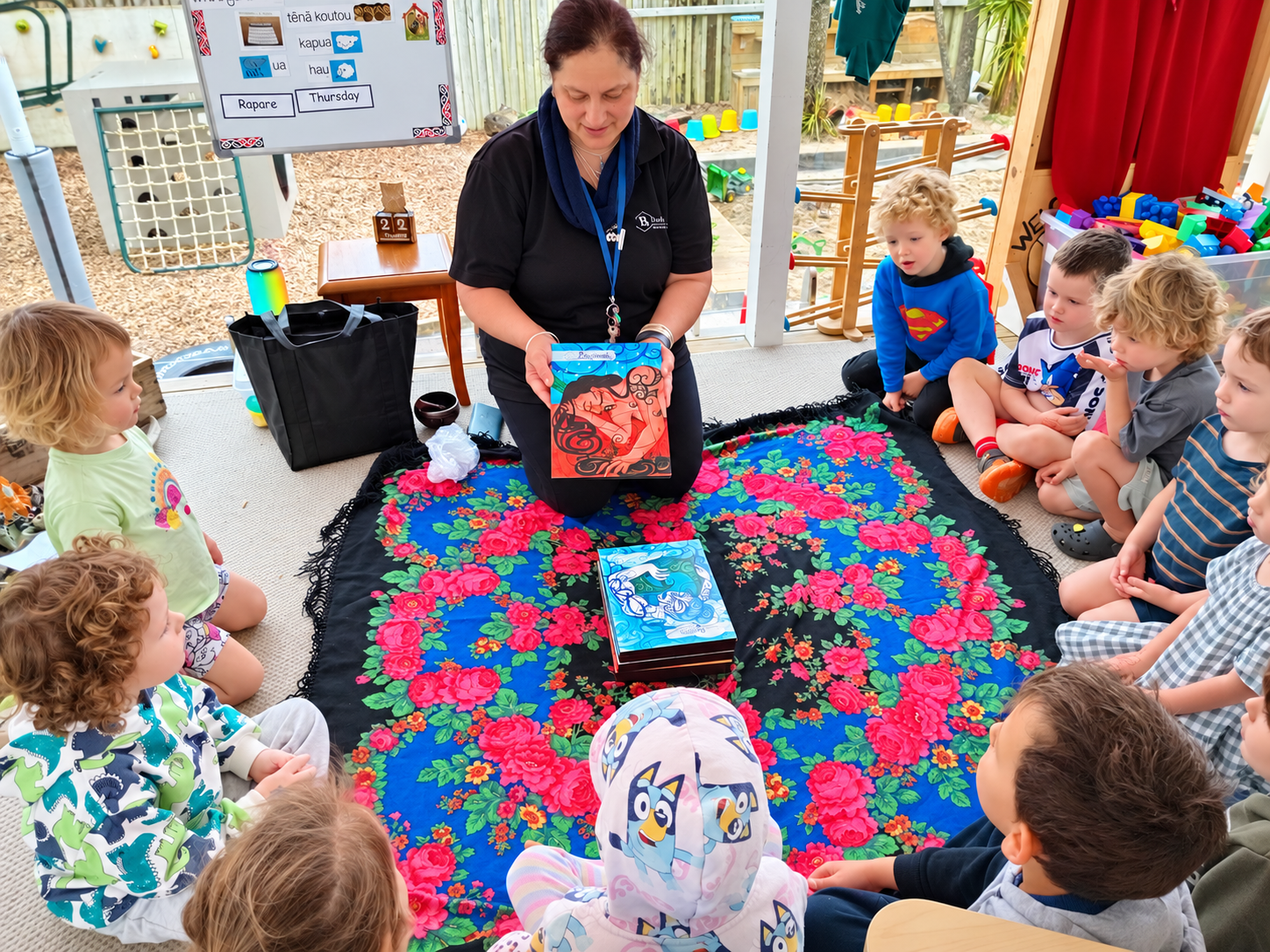 Teacher reading a story to a group of children at mat time