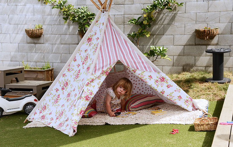 Girl playing inside a play tent