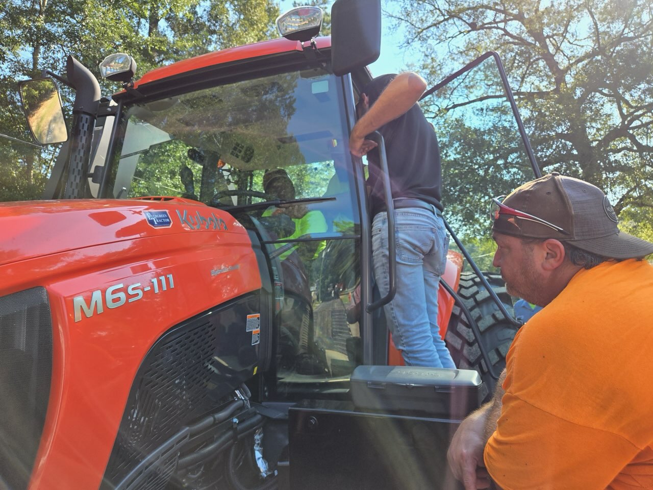 Evergreen Tractor team going over a Kubota M6S-111 tractor with a customer