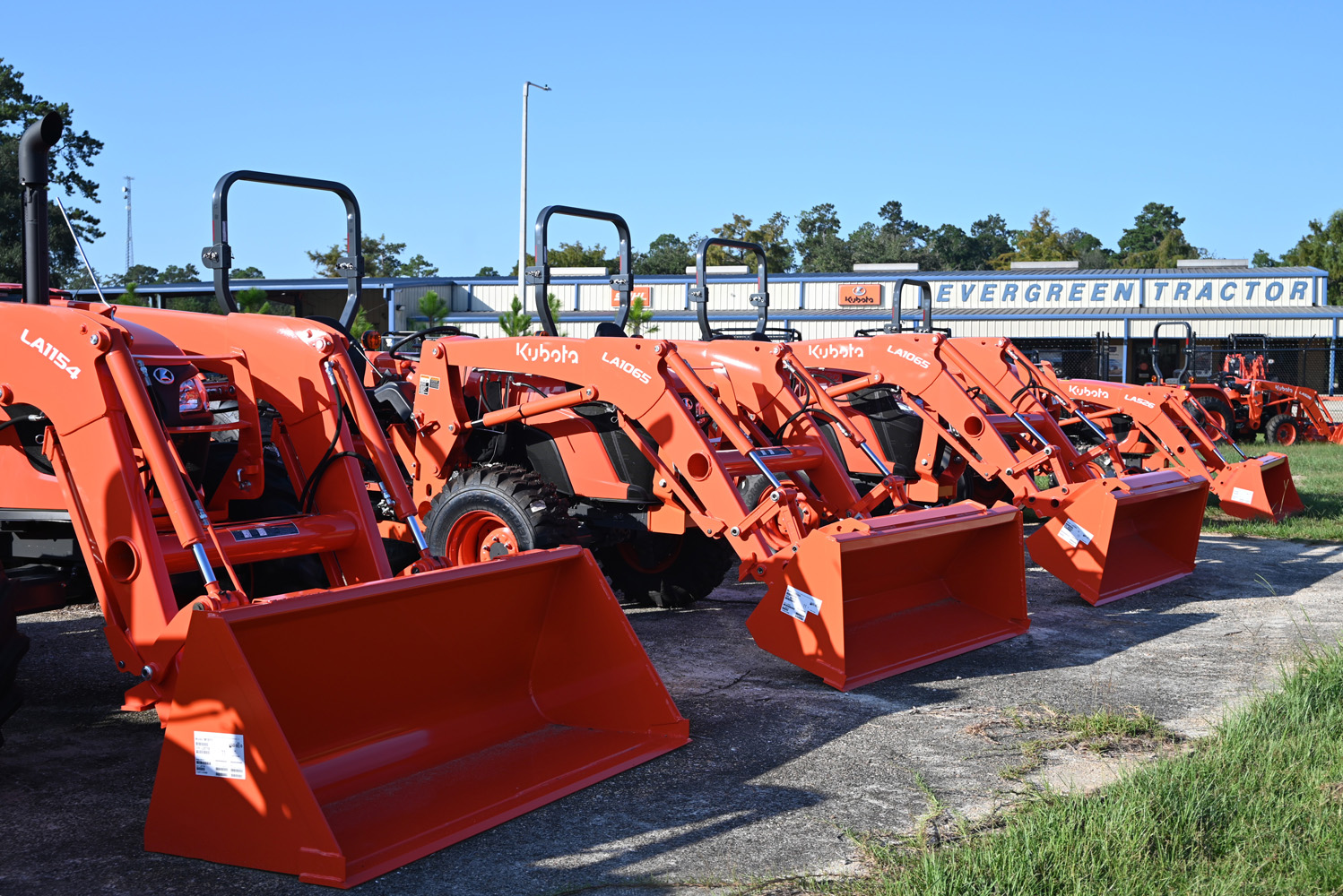 Row of Kubota tractors with loaders lined up at the Evergreen Tractor dealership in Covington, LA