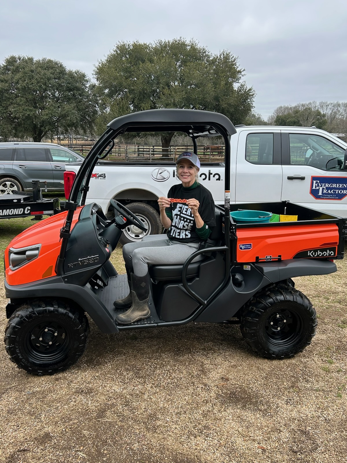 Customer seated in her new orange Kubota RTV520 utility vehicle