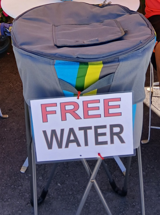 Self-serve cooler with a Free Water sign outside Iron Eagle Gyms.