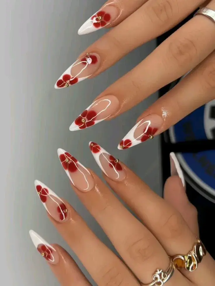White French stiletto nails with red flowers and gold beads