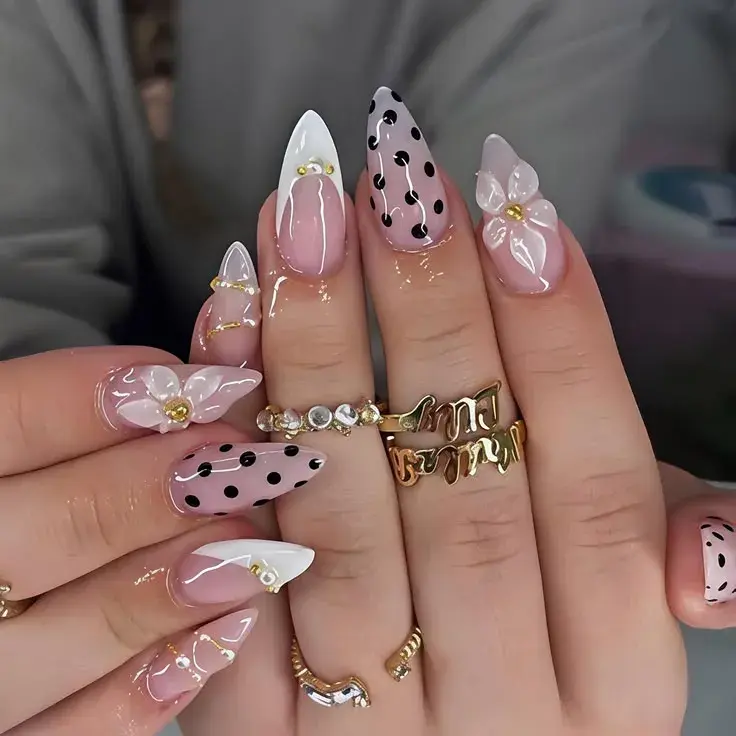 Pink polka dot nails with 3D white flower accent