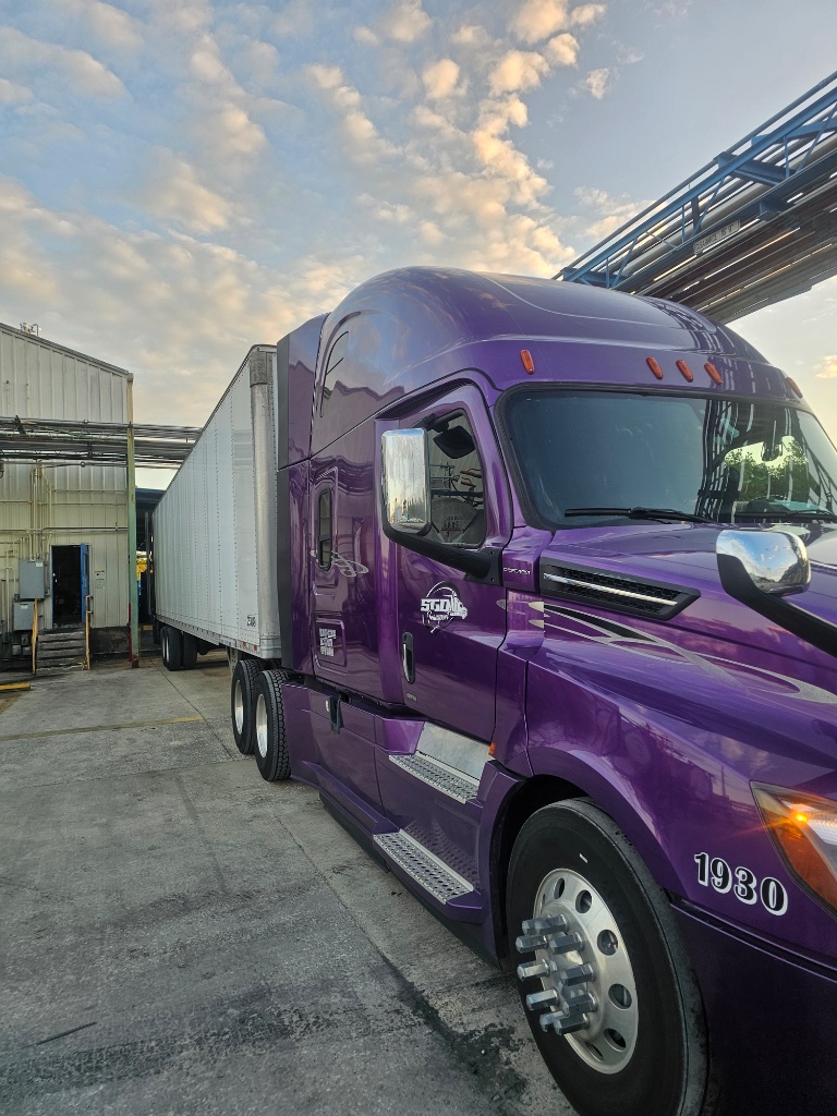 SGD Transport silver Freightliner with dry van trailer at dock
