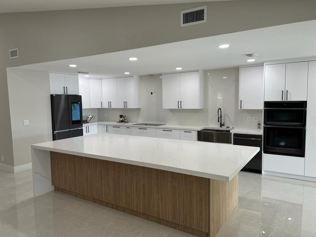 Open Concept White Kitchen — Quartz Island — South Florida by Carbon Haus Construction