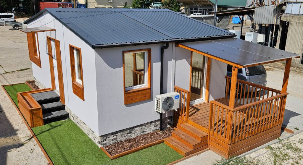 Készletről eladó 38 m²-es teraszos modulház fa terasszal és szürke homlokzattal