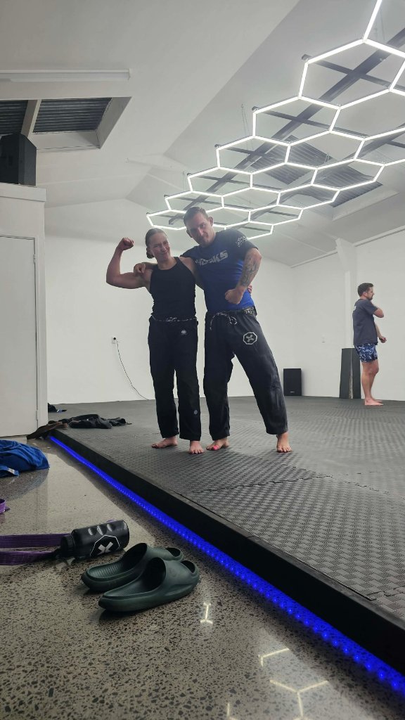 Two Guardian Jiu Jitsu students in gis standing on the mats