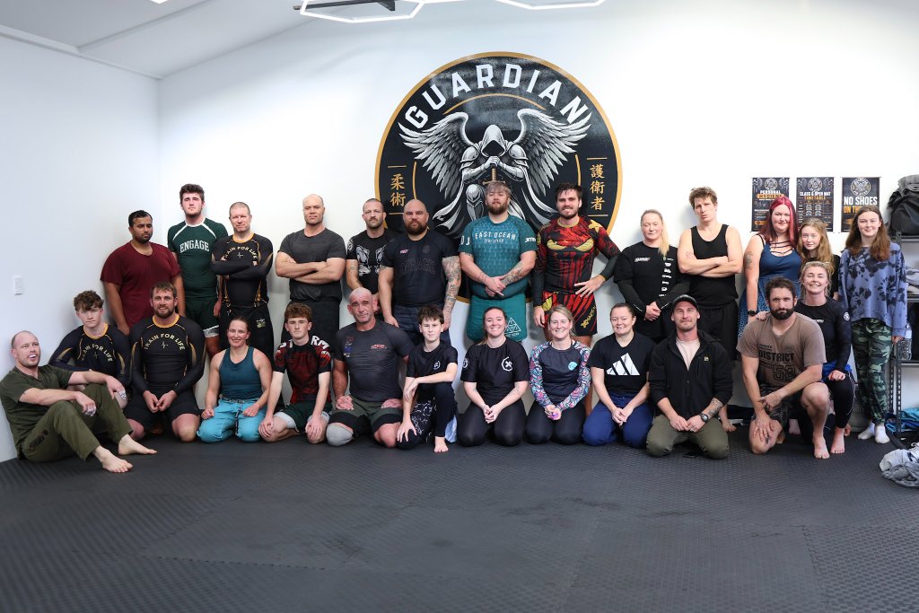 The Guardian Jiu Jitsu team posing together on the mats