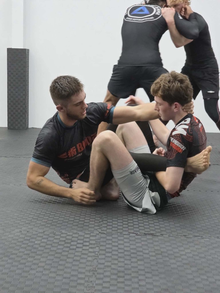 Two students sparring on the mats at Guardian Jiu Jitsu