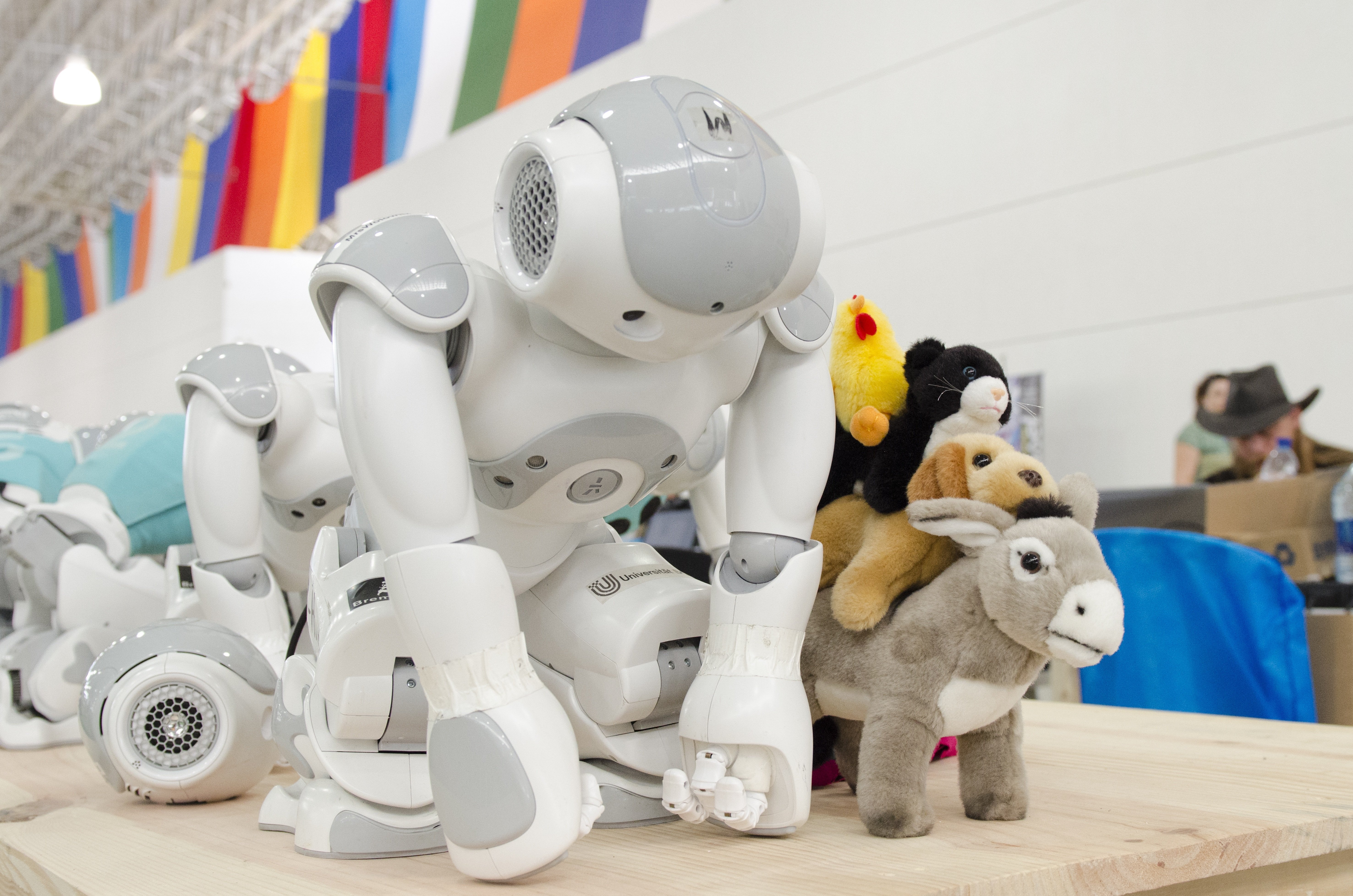 Humanoid Nao robot interacting with plush toys on a table, demonstrating psychomotor capability