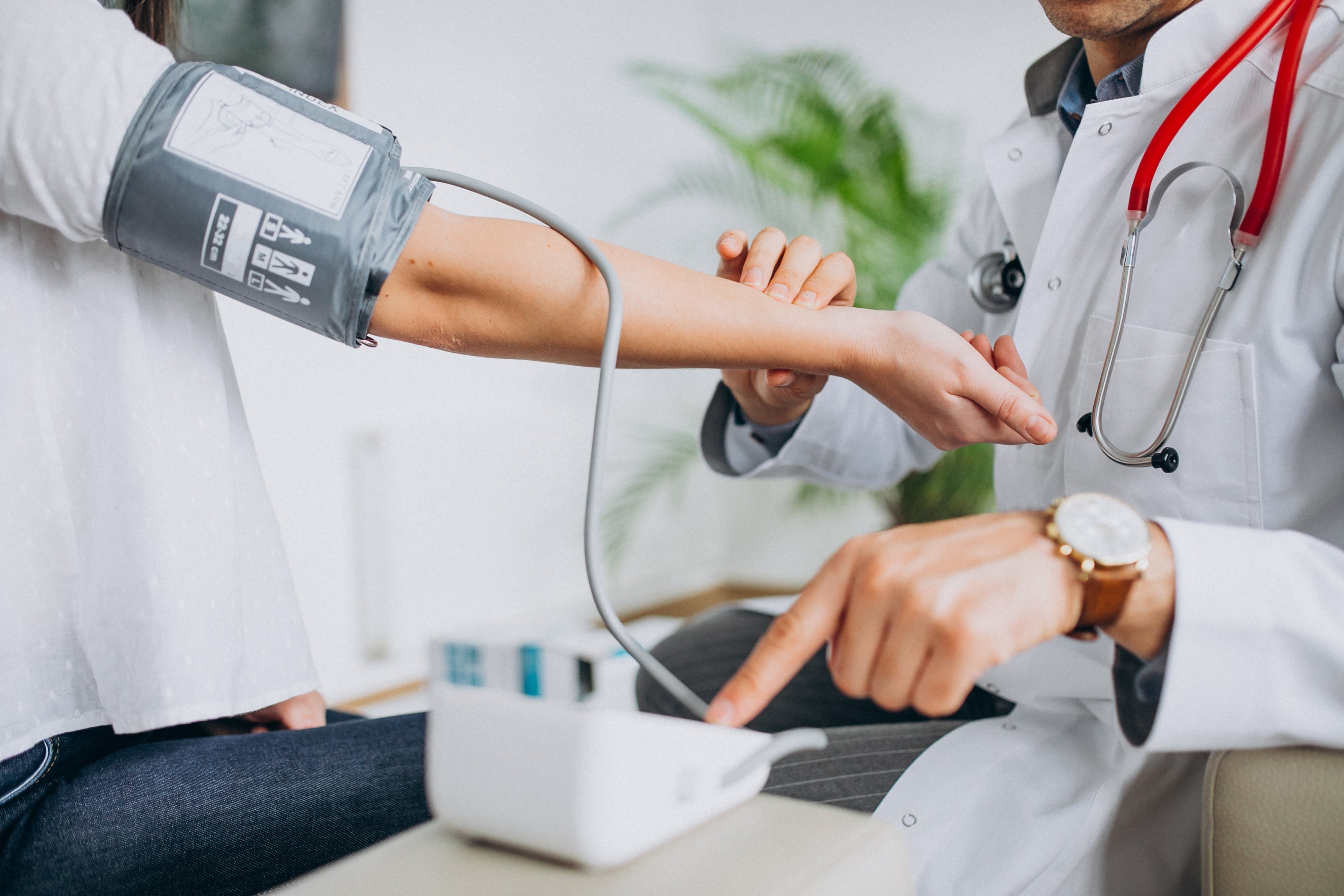 Doctor examining a patient's pulse and blood pressure with a digital monitor, symbolising medical education's focus on professional behaviour