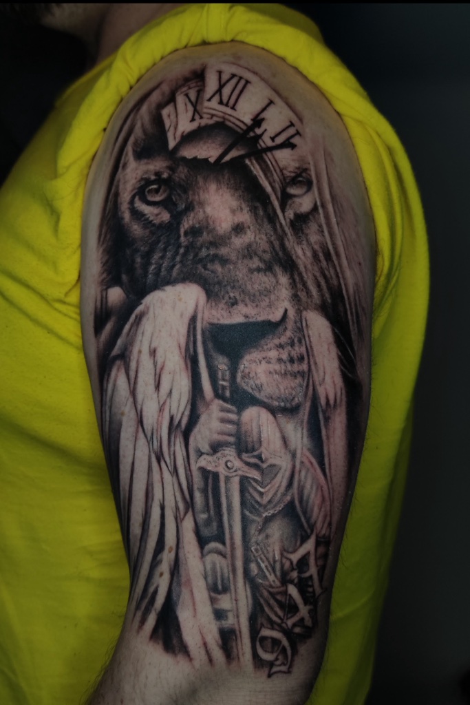 Lion and angel black and grey arm tattoo by V01 Ink