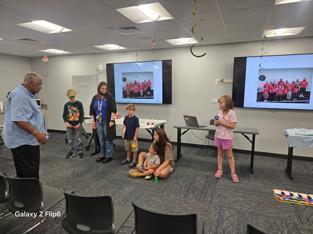 Group of students and mentors gathered for a music lesson