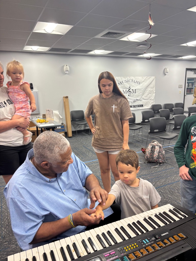 Mentor teaching a young student piano keys