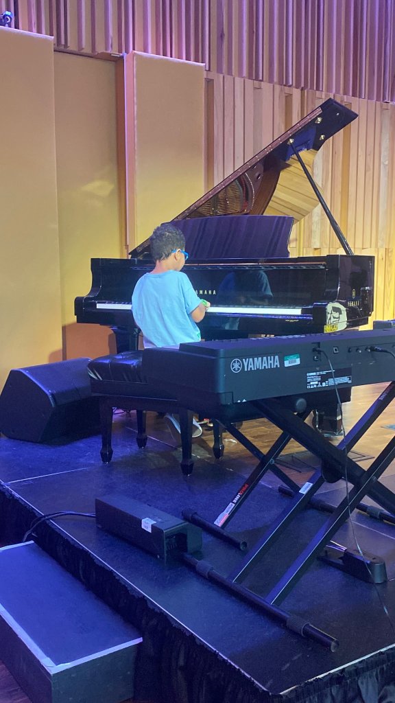 Young student performing on grand piano
