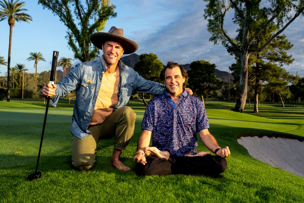 Ian Lopatin sitting on a golf course with a friend