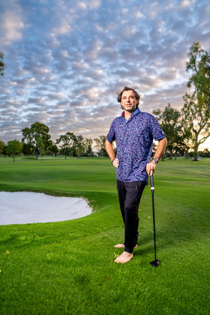Ian Lopatin standing barefoot on a golf course