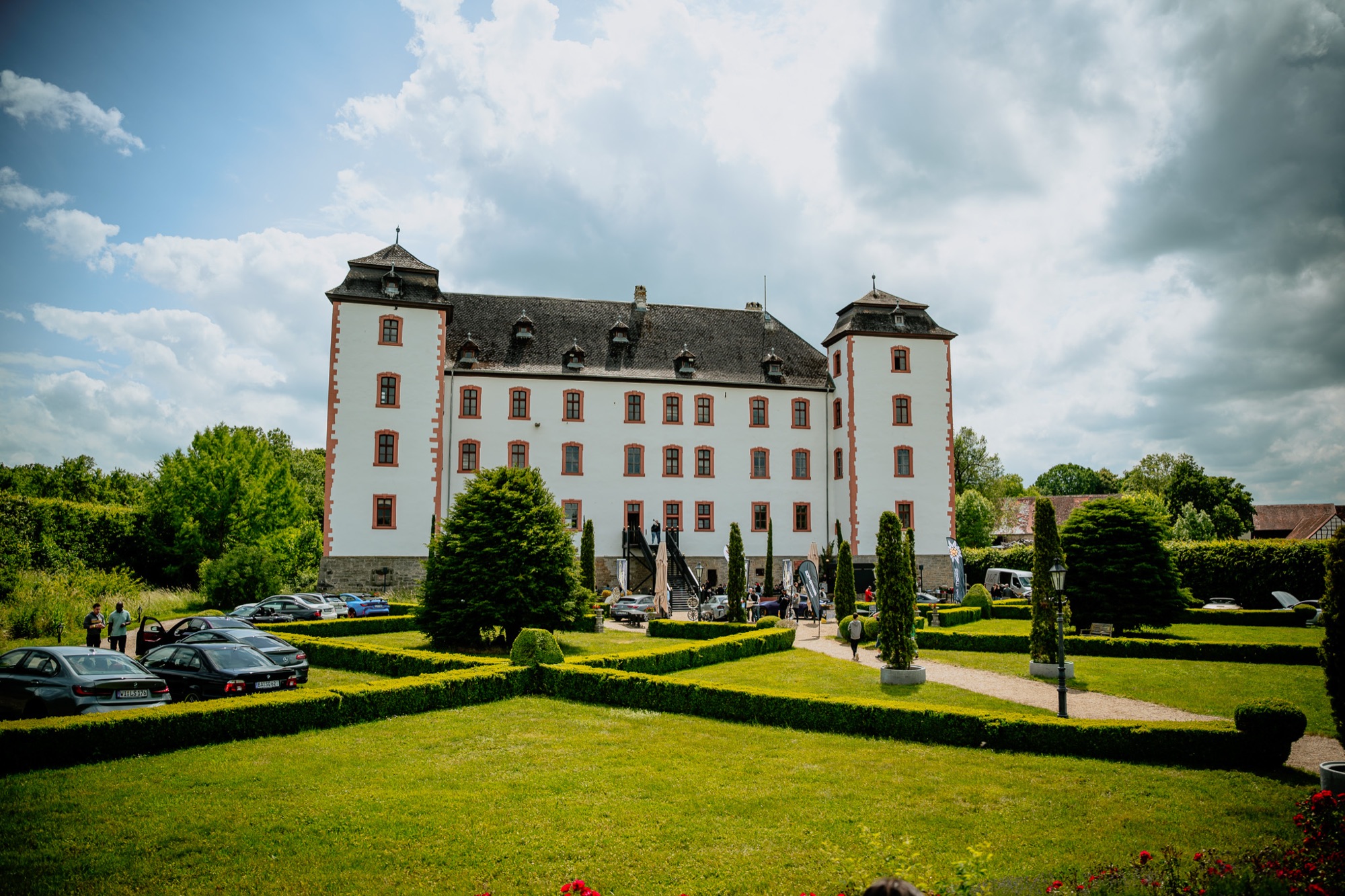 Schloss Walkershofen mit Fahrzeugen im Park