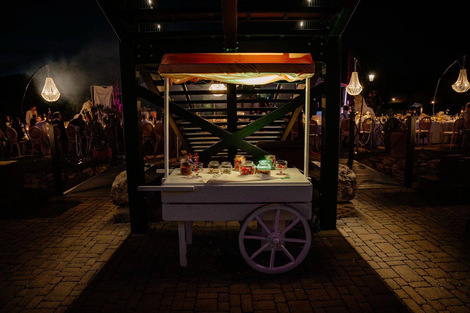 Drei Cocktails auf der Bartheke, dahinter feiernde Gäste
