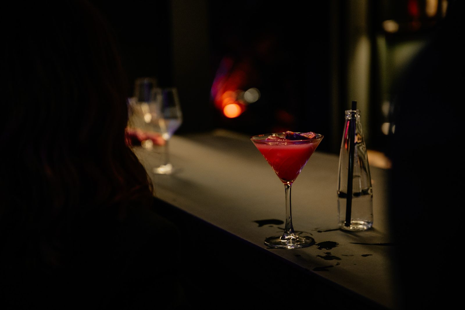 Beleuchtete Outdoor-Bar mit Gästen vor der violett angestrahlten Schlossfassade