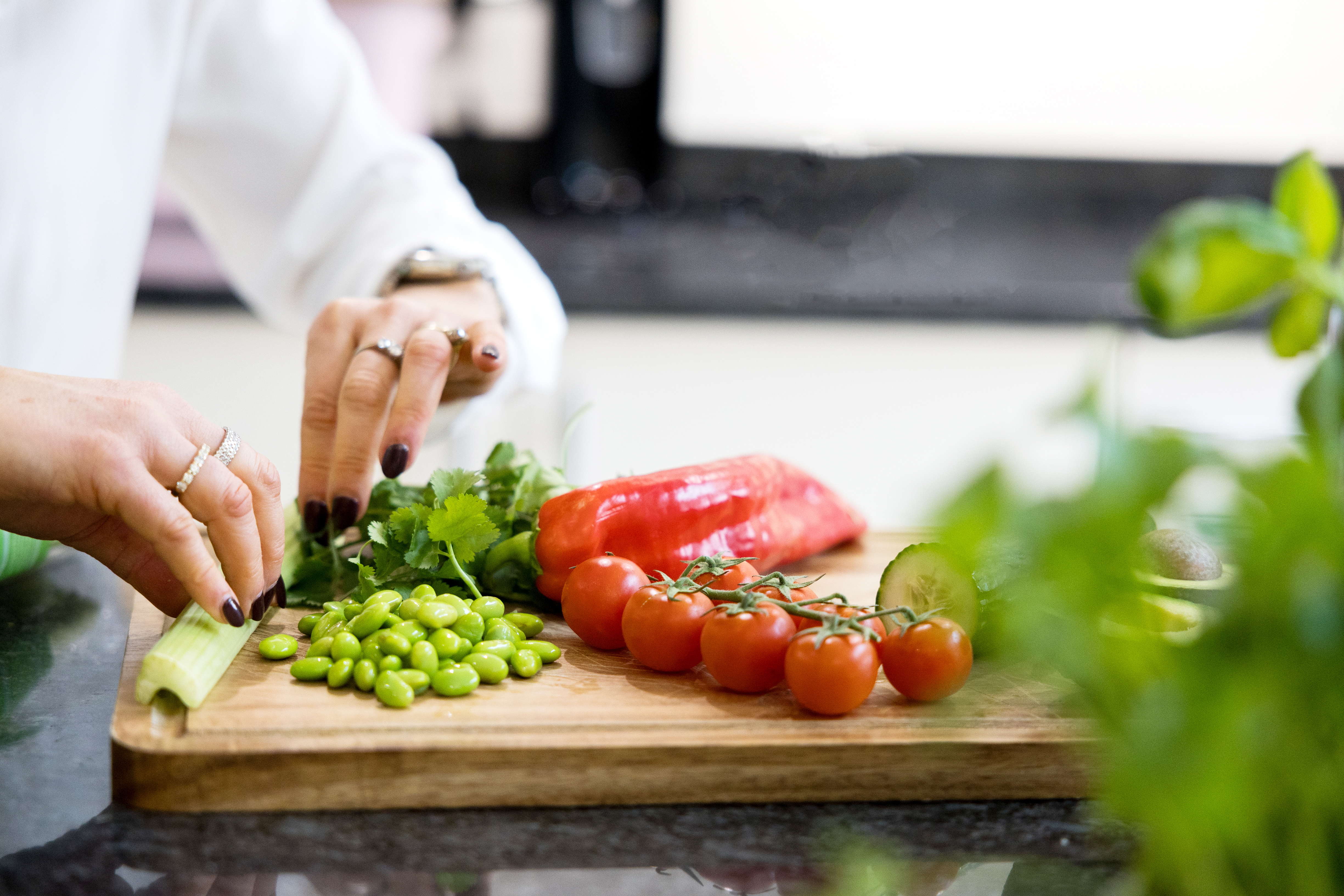 Fresh vegetables being prepared on a wooden cutting board
