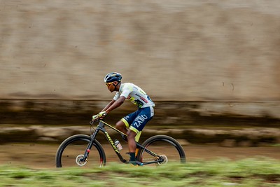 A mountain bike racer in motion on a dirt track
