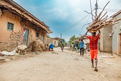 A village dirt path with cyclists and locals in rural Rwanda