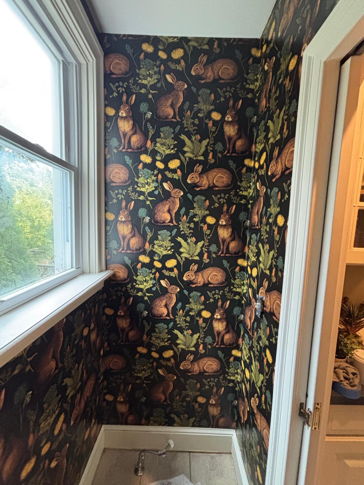 Dark rabbit and wildflower wallpaper in a powder room