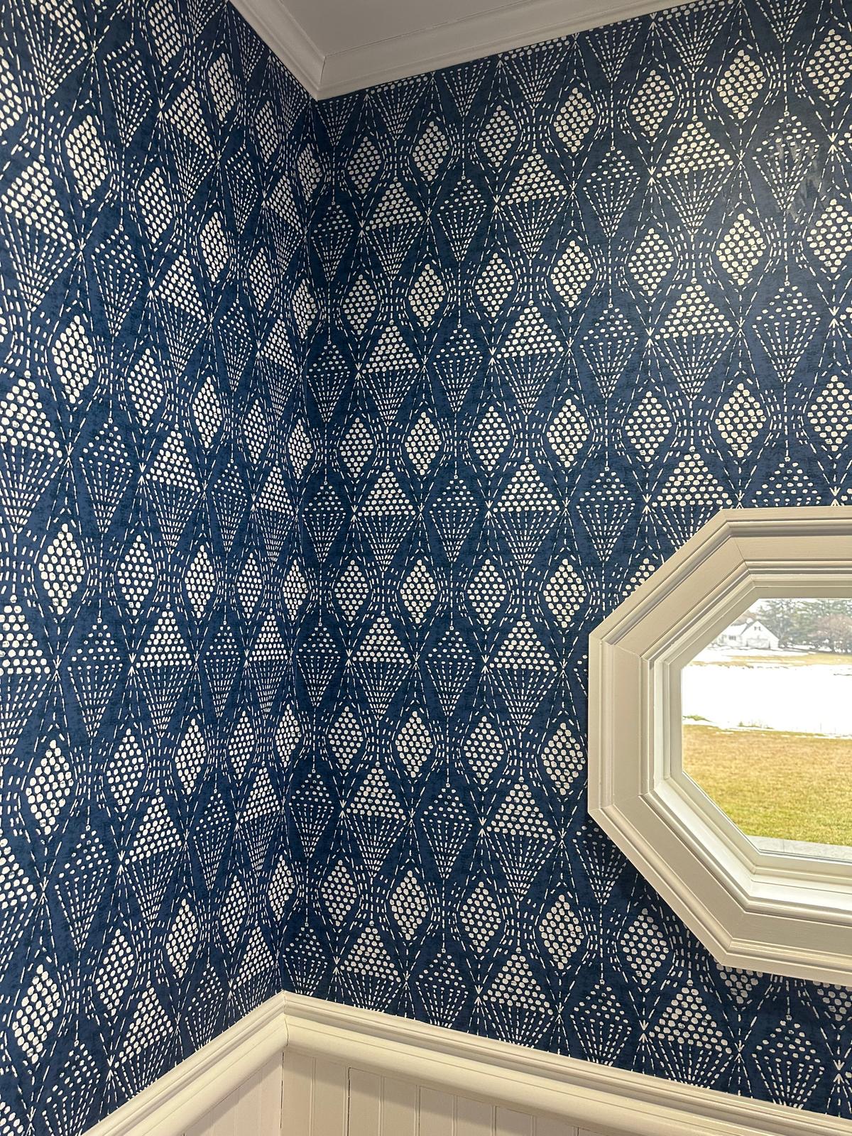 Navy geometric wallpaper in a powder room corner