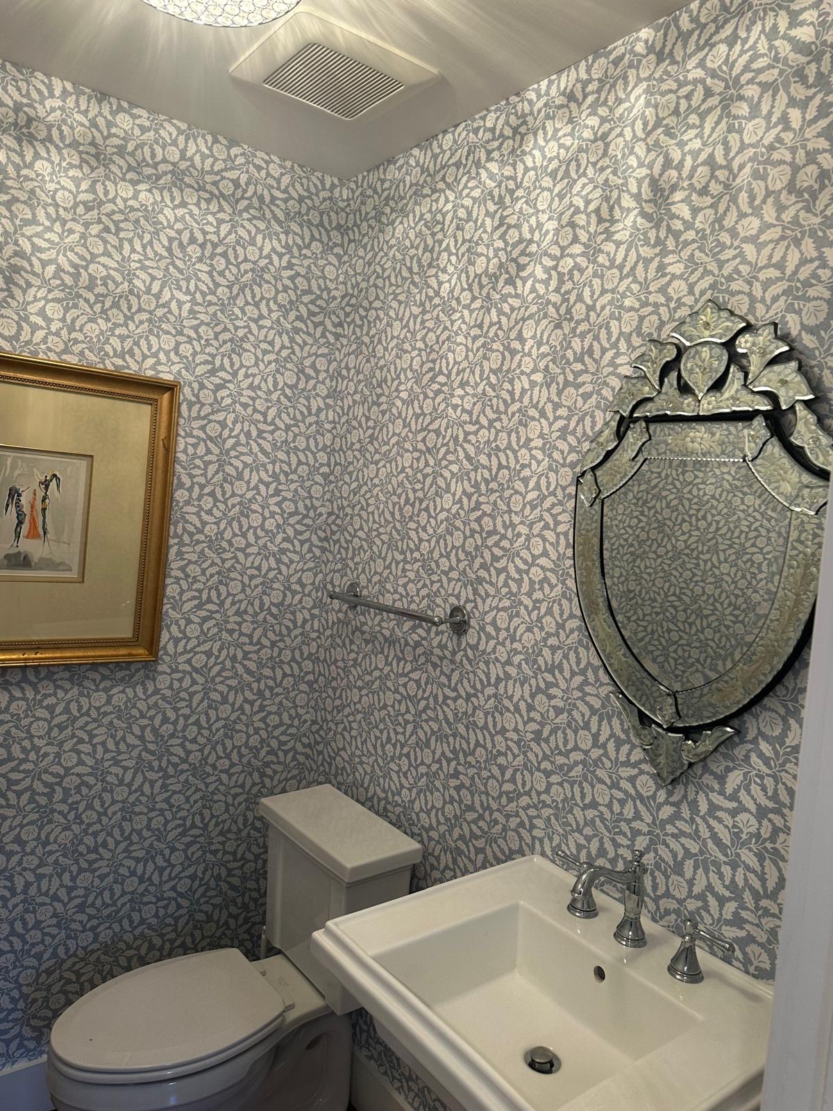 Blue leaf pattern wallpaper in a powder room