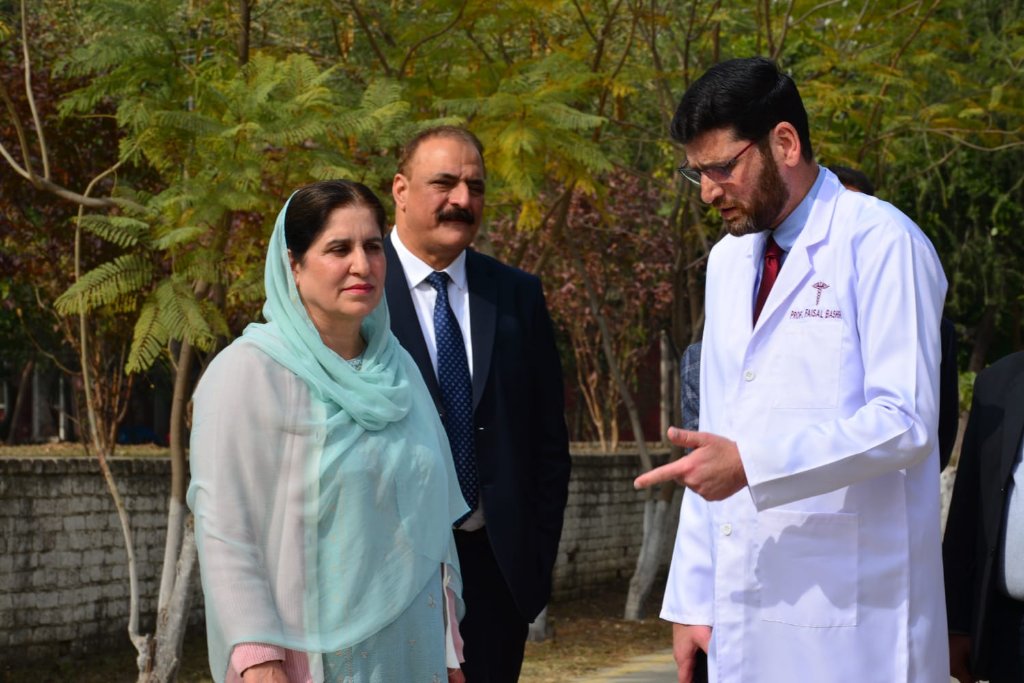 Principal in discussion with guests on campus