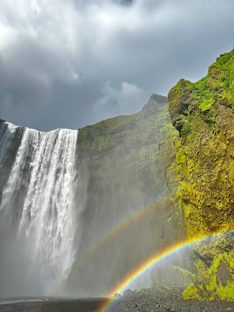 Skógafoss waterfall in Iceland with a double rainbow at its base