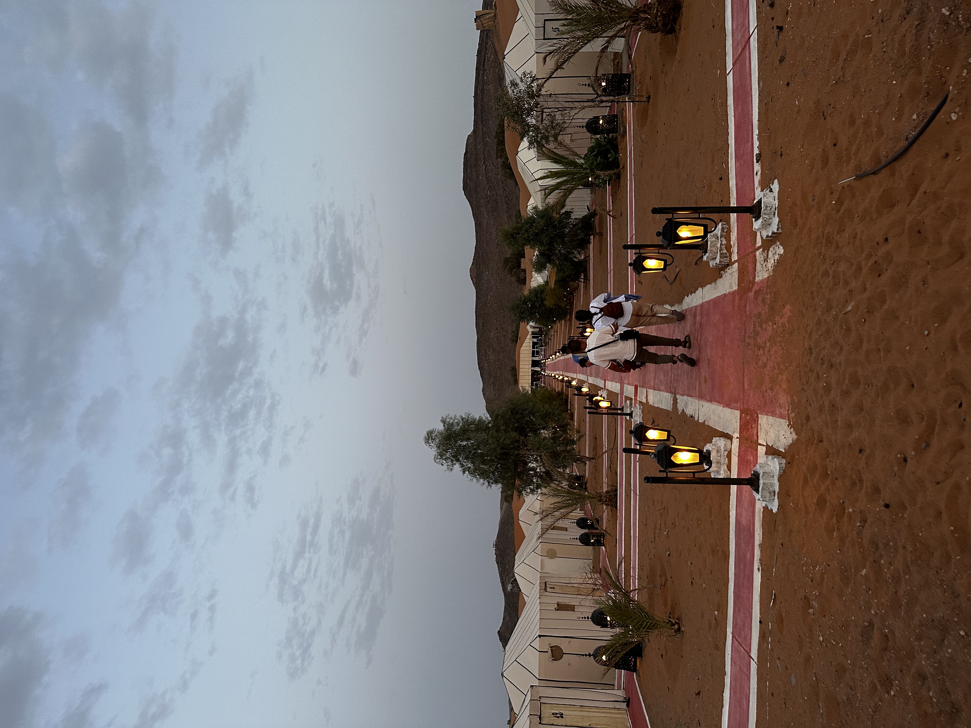 Lantern-lit path through the Sahara desert camp at night