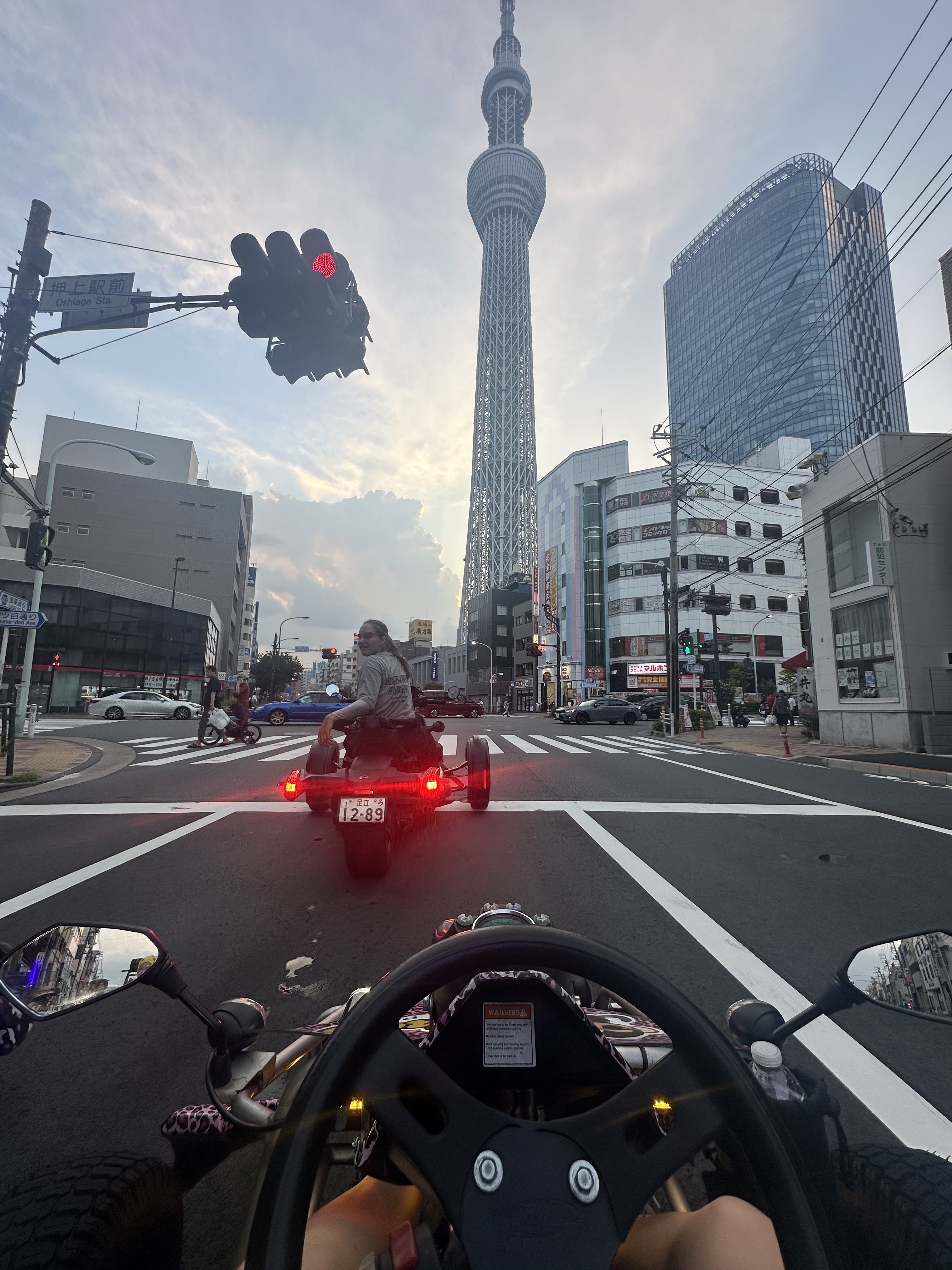 First-person view from a go-kart driving through Tokyo at dusk with the Tokyo Skytree in the background