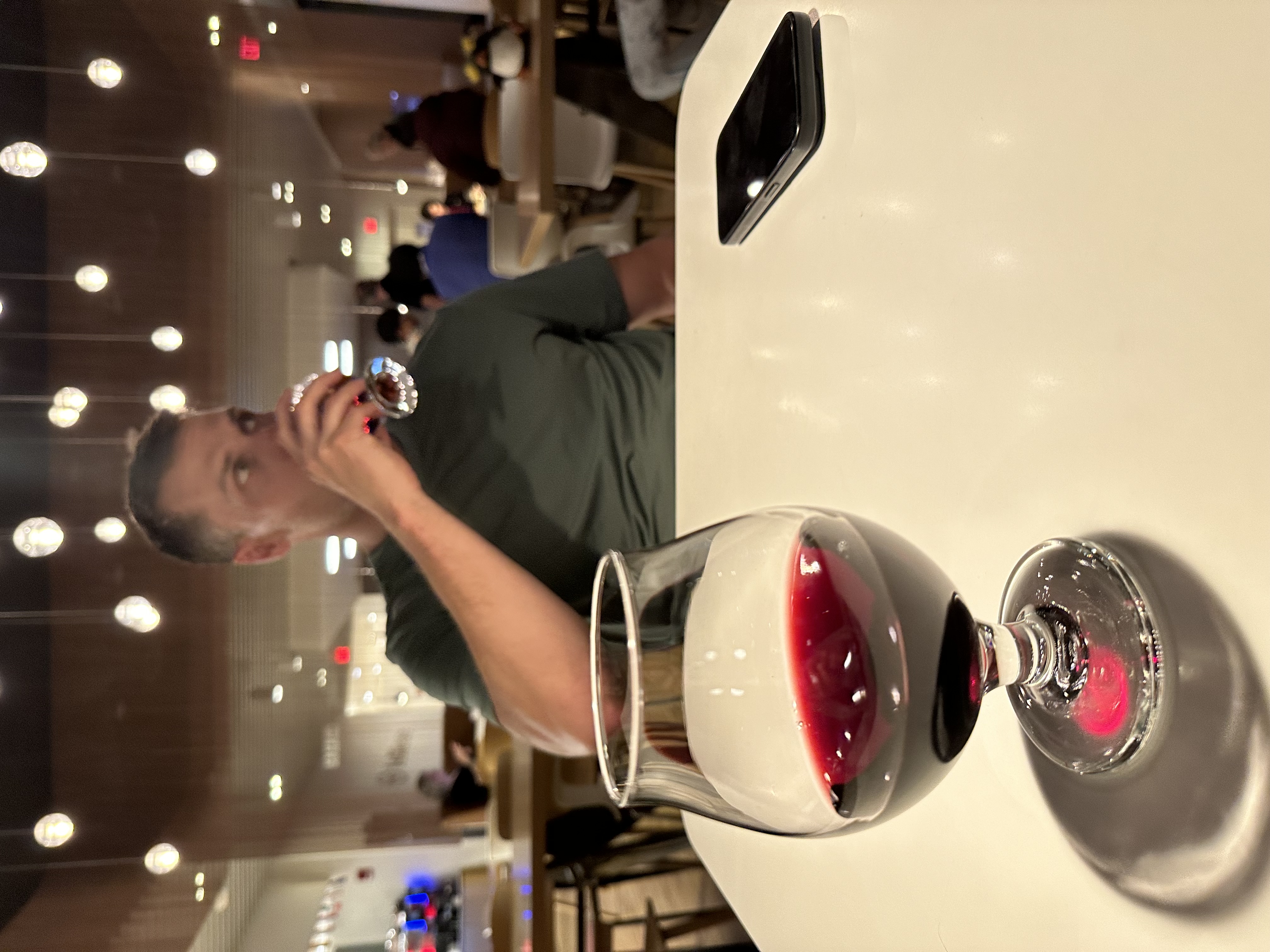 A glass of red wine enjoyed in a premium airline lounge before the flight