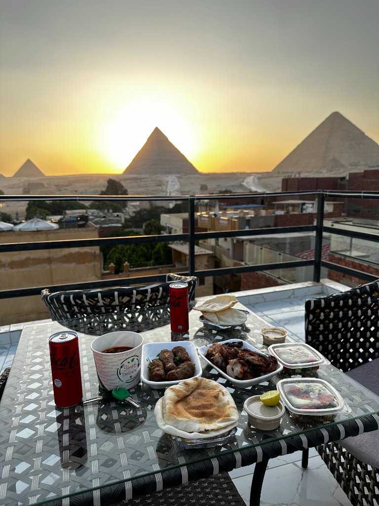 Rooftop view overlooking the Pyramids of Giza at sunset