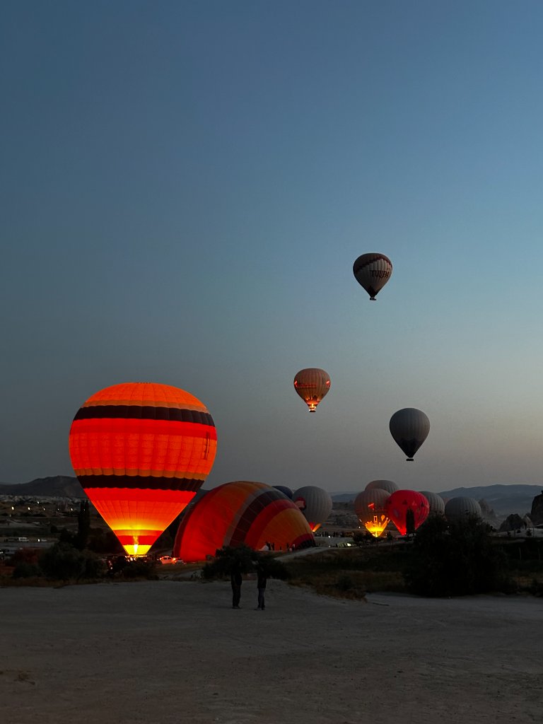 Pre-dawn hot air balloons glowing against twilight sky