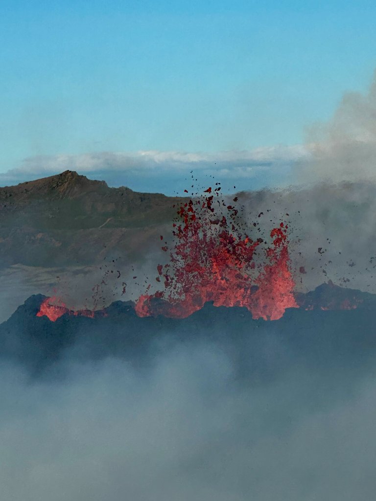A volcanic eruption in Iceland with bright orange lava fountains shooting into the air